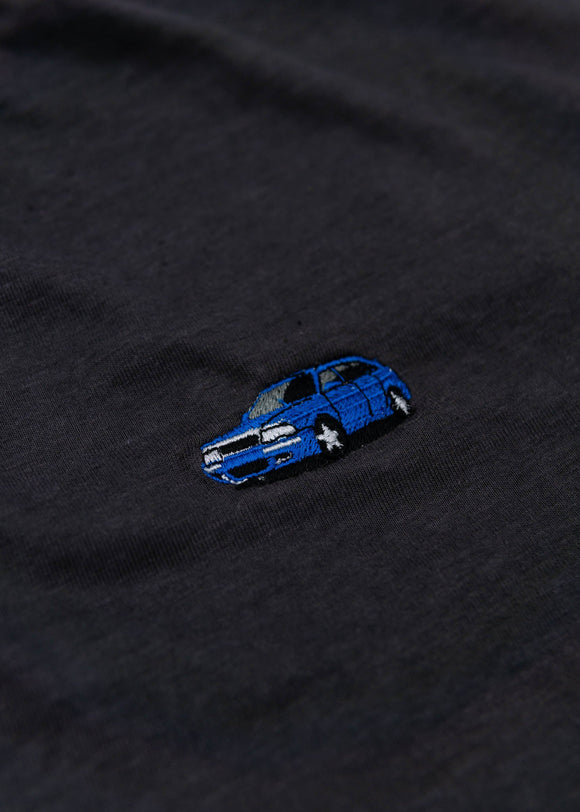 A dark grey cropped t-shirt for Audi women. Close up view of a 100% cotton crop tee with an embroidered Nogaro Blue Audi 80 RS2 Avant made by Porsche. The material is stretchy, and non-transparent with a crewneck neckline and short sleeves.