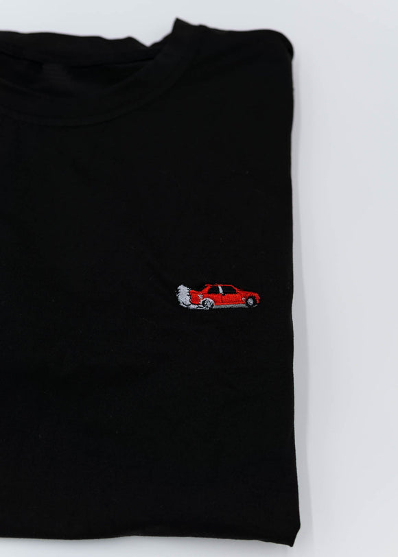 A black BMW/Bimmer E30 M3 T-Shirt for men. Photo is a close up of the shirt with an embroidered Red BMW E30 M3 Coupe. Fabric composition is 100% polyester. The material is very stretchy, soft, comfortable, breathable, and non-transparent. The style of this shirt is short sleeve, with a crewneck neckline.