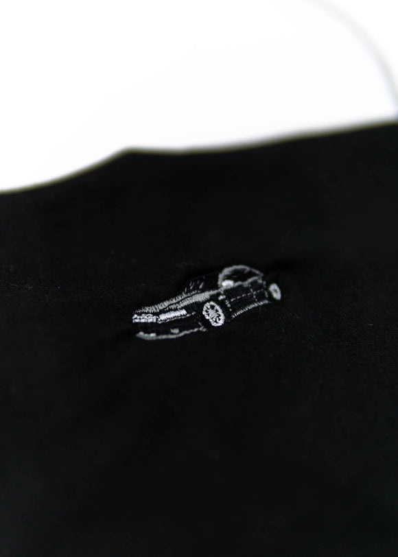 A black Audi crop top for women. Photo is a close up view of the shirt with an embroidered Black Audi D2 S8. Fabric composition is 100% polyester. The material is very soft, comfortable, non-transparent. The style of this shirt is sleeveless, spaghetti straps, with a straight neckline.