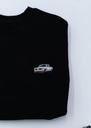 A black BMW crewneck sweater for men. Photo is a close up of the sweater with an embroidered BMW 2002 Turbo. Fabric is composed of high quality 80% cotton, and 20% polyester and fits to size. The style is long sleeve, crew neck, and embroidery on left chest.