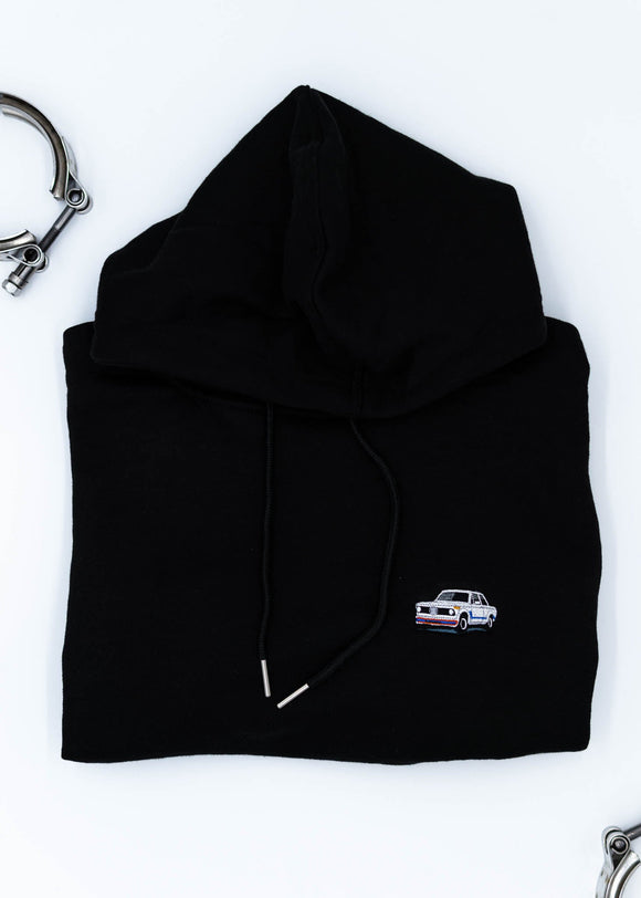 A black BMW cropped hoodie for women. Photo is a close up view of the cropped sweater with an embroidered BMW 2002 Turbo. Fabric composition is 100% cotton. The material is soft, comfortable, breathable, and non-transparent. The style of this crop hoodie is long sleeve, crewneck with a hood, hooded, with embroidery on the chest.