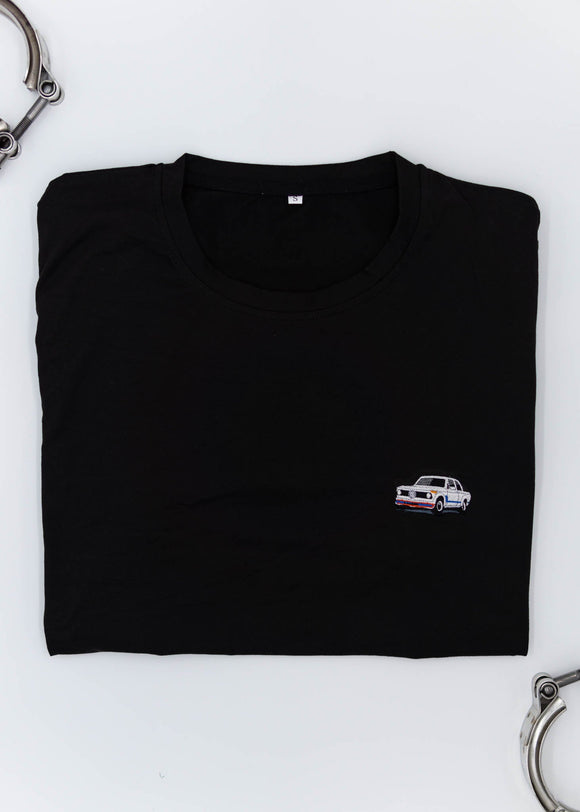 A black BMW 2002 Turbo t-shirt for men. Photo is a close up view of the shirt with an embroidered 2002 Turbo. Fabric composition is a polyester and cotton mix. The material is very soft, stretchy, non-transparent. The style of this shirt is short sleeve, with a crewneck neckline.