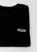Close up of an embroidered 991.2 GT2 RS on a women's high quality cropped t-shirt. Photo shows the detailed embroidery of a white, silver, and carbon fiber GT2 RS. Fabric composition of this tee is 100% cotton. The material is very soft, stretchy, and non-transparent. The style of this tshirt is a crewneck, short sleeve, cropped at the waist, with embroidery on the left chest.