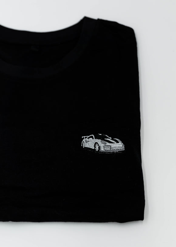 Close up of an embroidered 991.2 GT2 RS on a women's high quality cropped t-shirt. Photo shows the detailed embroidery of a white, silver, and carbon fiber GT2 RS. Fabric composition of this tee is 100% cotton. The material is very soft, stretchy, and non-transparent. The style of this tshirt is a crewneck, short sleeve, cropped at the waist, with embroidery on the left chest.
