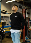 Male model in a black 2002 Turbo crewneck sweater.