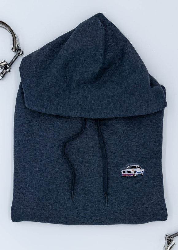 A dark blue BMW unisex hoodie for men and women. Photo is a close up view of the sweater with an embroidered BMW 2002 Turbo. Fabric composition is cotton, polyester, and rayon. The material is very soft, stretchy, and non-transparent. The style of this hoodie is long sleeve, crewneck with a hood, hooded, with embroidery on the left chest.