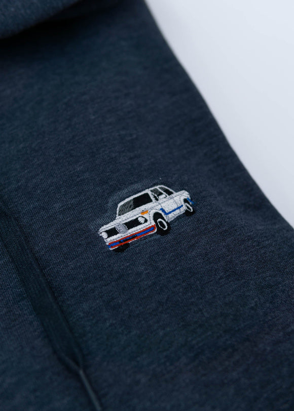 A dark blue BMW unisex hoodie for men and women. Photo is a close up view of the sweater with an embroidered BMW 2002 Turbo. Fabric composition is cotton, polyester, and rayon. The material is very soft, stretchy, and non-transparent. The style of this hoodie is long sleeve, crewneck with a hood, hooded, with embroidery on the left chest.
