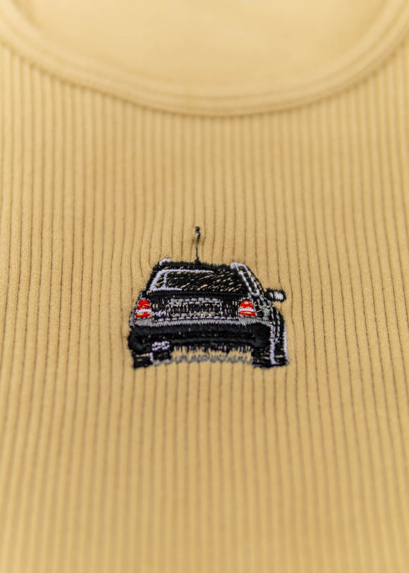 A khaki Audi crop top for women. Photo is a close up view of the top with an embroidered black Audi B5 RS4. Fabric composition is polyester, and elastine. The material is stretchy, ribbed, and non-transparent. The style of this shirt is sleeveless, with a crewneck neckline.