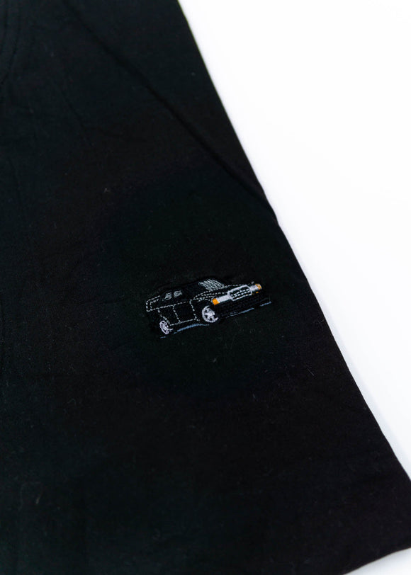 A black Mercedes-Benz t-shirt for men. Photo is a close up of the shirt with an embroidered black W201 190E Evo II. Fabric composition is a polyester. The material is very soft, stretchy, non-transparent. The style of this shirt is short sleeve, with a crewneck neckline.