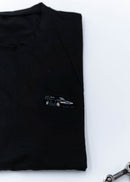 A black Mercedes-Benz t-shirt for men. Photo is a close up of the shirt with an embroidered black W201 190E Evo II. Fabric composition is a polyester. The material is very soft, stretchy, non-transparent. The style of this shirt is short sleeve, with a crewneck neckline.