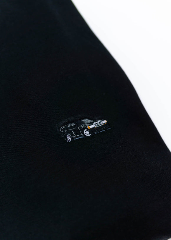A black Mercedes-Benz crewneck sweater for men. Photo is a close up of the sweater with an embroidered Mercedes-Benz W201 190E 2.5-16 Evo II. Fabric is composed of high quality 80% cotton, and 20% polyester and fits to size. The style is long sleeve, crew neck, and embroidery on left chest.