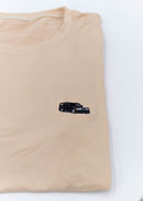 A khaki Mercedes-Benz t-shirt for men. Photo is a close up view of the shirt with an embroidered black W201 190E 2.5-16 Evo II. Fabric composition is a polyester, and cotton mix. The material is very soft, stretchy, non-transparent. The style of this shirt is short sleeve, with a crewneck neckline.