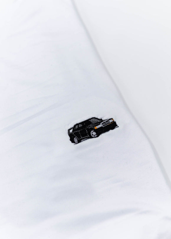A white Mercedes-Benz t-shirt for men. Photo is a close up view of the shirt with an embroidered black W201 190E 2.5-16 Evo II. Fabric composition is a polyester, and cotton mix. The material is very soft, stretchy, non-transparent. The style of this shirt is short sleeve, with a crewneck neckline.