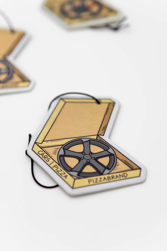 A pizzabrand pizza box with wheels multipack sampler pack air fresheners. Photo is a close up of the Audi Rotor wheel air freshener with string. 