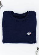 A navy blue Porsche race car crewneck sweater for men. Photo is a front view of the sweater with an embroidered Martini R13 Porsche 911 Carrera RSR 2.1 Turbo . Fabric is 100% cotton and high quality and fits to size. The style is long sleeve, crew neck, and embroidery on left chest.