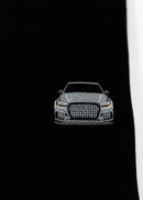Close up of an embroidered 8V RS3 on a black men's high quality crewneck sweater. Photo shows the high quality detailed embroidery of a nardo grey 8V RS3. Fabric composition of the shirt is cotton and polyester. The material is very soft, stretchy, and non-transparent. The style of this sweater is a crewneck, long sleeve, elastic bottom, with embroidery on the left chest.