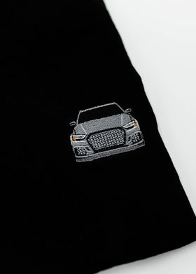 Close up of an embroidered 8V RS3 on a women's high quality cropped t-shirt. Photo shows the detailed embroidery of a nardo grey 8V RS3. Fabric composition of this tee is 100% cotton. The material is very soft, stretchy, and non-transparent. The style of this tshirt is a crewneck, short sleeve, cropped at the waist, with embroidery on the left chest.