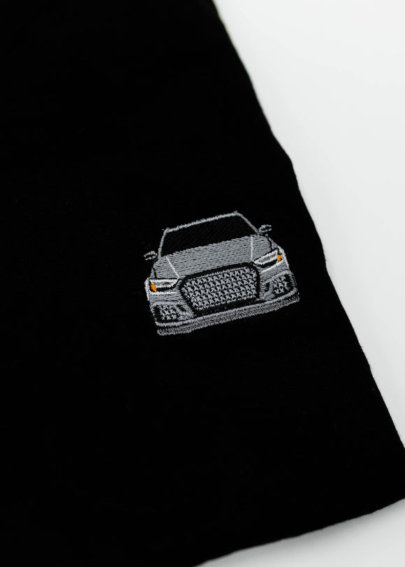 Close up of an embroidered 8V RS3 on a women's high quality cropped t-shirt. Photo shows the detailed embroidery of a nardo grey 8V RS3. Fabric composition of this tee is 100% cotton. The material is very soft, stretchy, and non-transparent. The style of this tshirt is a crewneck, short sleeve, cropped at the waist, with embroidery on the left chest.