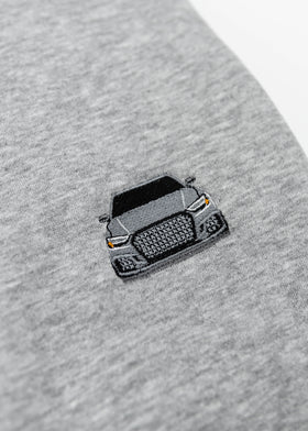 Close up of an embroidered 8V RS3 on a light grey unisex hoodie for men and women. Photo shows the high quality detailed embroidery of an 8V RS3 on the left chest. Fabric composition of the sweater is cotton, polyester, and rayon. The material is very soft, stretchy, and non-transparent. The style of this hoodie is long sleeve, crewneck with a hood, hooded, with embroidery on the left chest.