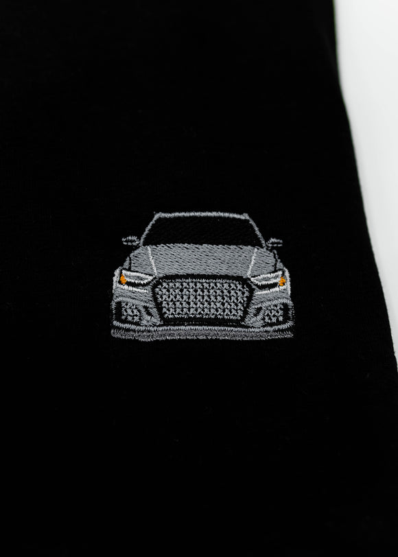 Close up of an embroidered 8V RS3 on a black men's cotton t-shirt. Photo shows the high quality detailed embroidery of a nardo grey 8V RS3. Fabric composition of the shirt is polyester and cotton. The material is very soft, stretchy, and non-transparent. The style of this t-shirt is short sleeve, round bottom, crewneck, with embroidery on the left chest.