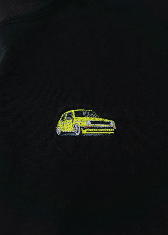 A black cropped t-shirt for VW women and plus size women. Close up of a 100% cotton crop tee with an embroidered VW Mk1 Golf. The material is stretchy, and non-transparent with a crewneck neckline and short sleeves.