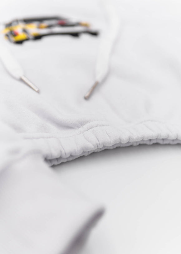 A white Audi cropped hoodie for women. Photo is a front view of the cropped sweater with an embroidered Sport Quattro S1 E2. Fabric composition is cotton, and polyester. The material is soft, stretchy, and non-transparent. The style of this crop hoodie is long sleeve, crewneck with a hood, hooded, with embroidery on the chest.