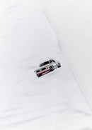 A white BMW 2002 Turbo t-shirt for men. Photo is a close up of the shirt with an embroidered 2002 Turbo. Fabric composition is a polyester and cotton mix. The material is very soft, stretchy, non-transparent. The style of this shirt is short sleeve, with a crewneck neckline.