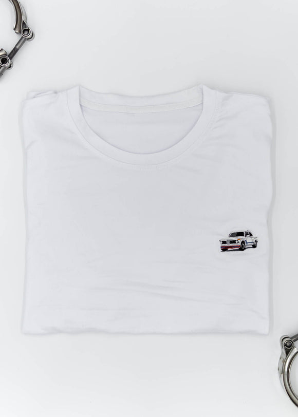 A white BMW 2002 Turbo t-shirt for men. Photo is a close up of the shirt with an embroidered 2002 Turbo. Fabric composition is a polyester and cotton mix. The material is very soft, stretchy, non-transparent. The style of this shirt is short sleeve, with a crewneck neckline.