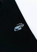 A black 911 RSR 2.1 Turbo T-Shirt for men. Photo is a close up view of the shirt with an embroidered 911 RSR 2.1 Turbo. Fabric composition is 65% polyester, and 35% cotton. The material is very stretchy, soft, comfortable, breathable, and non-transparent. The style of this shirt is short sleeve, with a crewneck neckline.