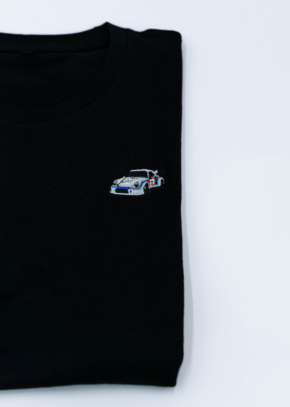 A black 911 RSR 2.1 Turbo T-Shirt for men. Photo is a close up view of the shirt with an embroidered 911 RSR 2.1 Turbo. Fabric composition is 65% polyester, and 35% cotton. The material is very stretchy, soft, comfortable, breathable, and non-transparent. The style of this shirt is short sleeve, with a crewneck neckline.