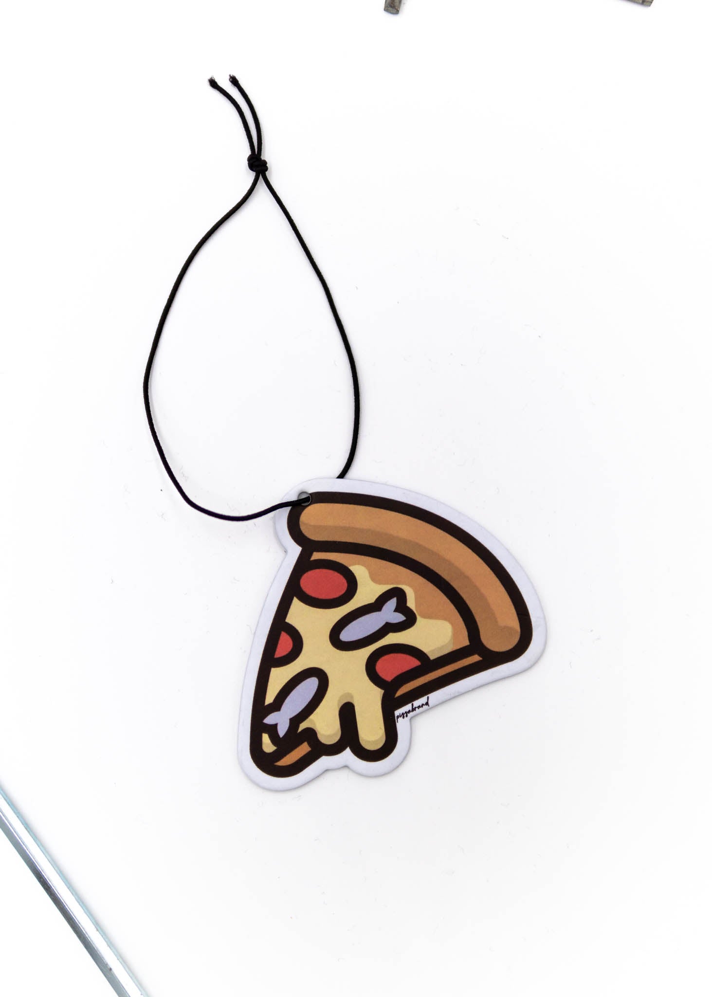 A pizzabrand anchovy and pepperonin air freshener. Photo is a close up of the car air freshener with string.