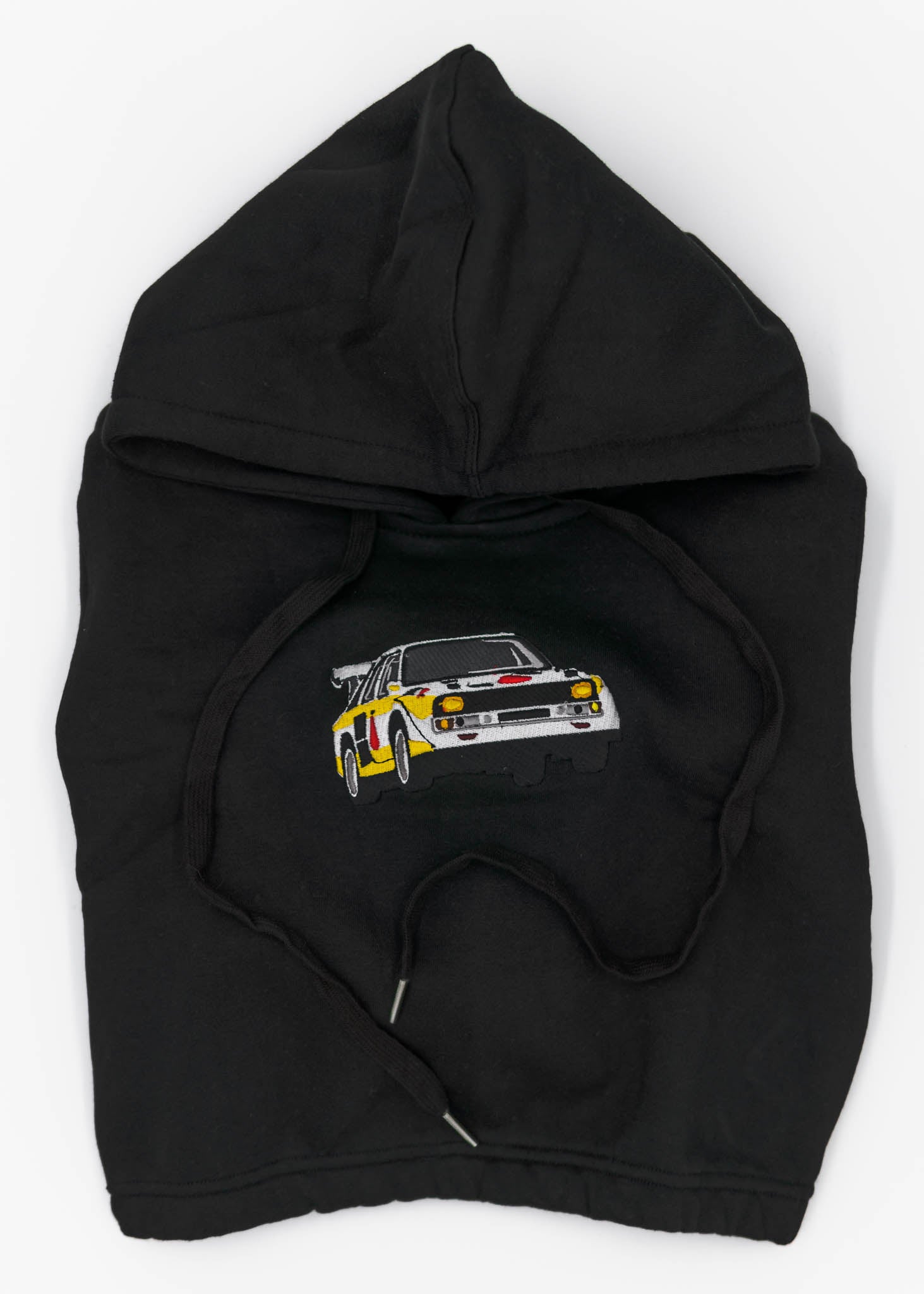 A black Audi cropped hoodie for women. Photo is a front view of the cropped sweater with an embroidered Sport Quattro S1 E2. Fabric composition is cotton, and polyester. The material is soft, stretchy, and non-transparent. The style of this crop hoodie is long sleeve, crewneck with a hood, hooded, with embroidery on the chest.