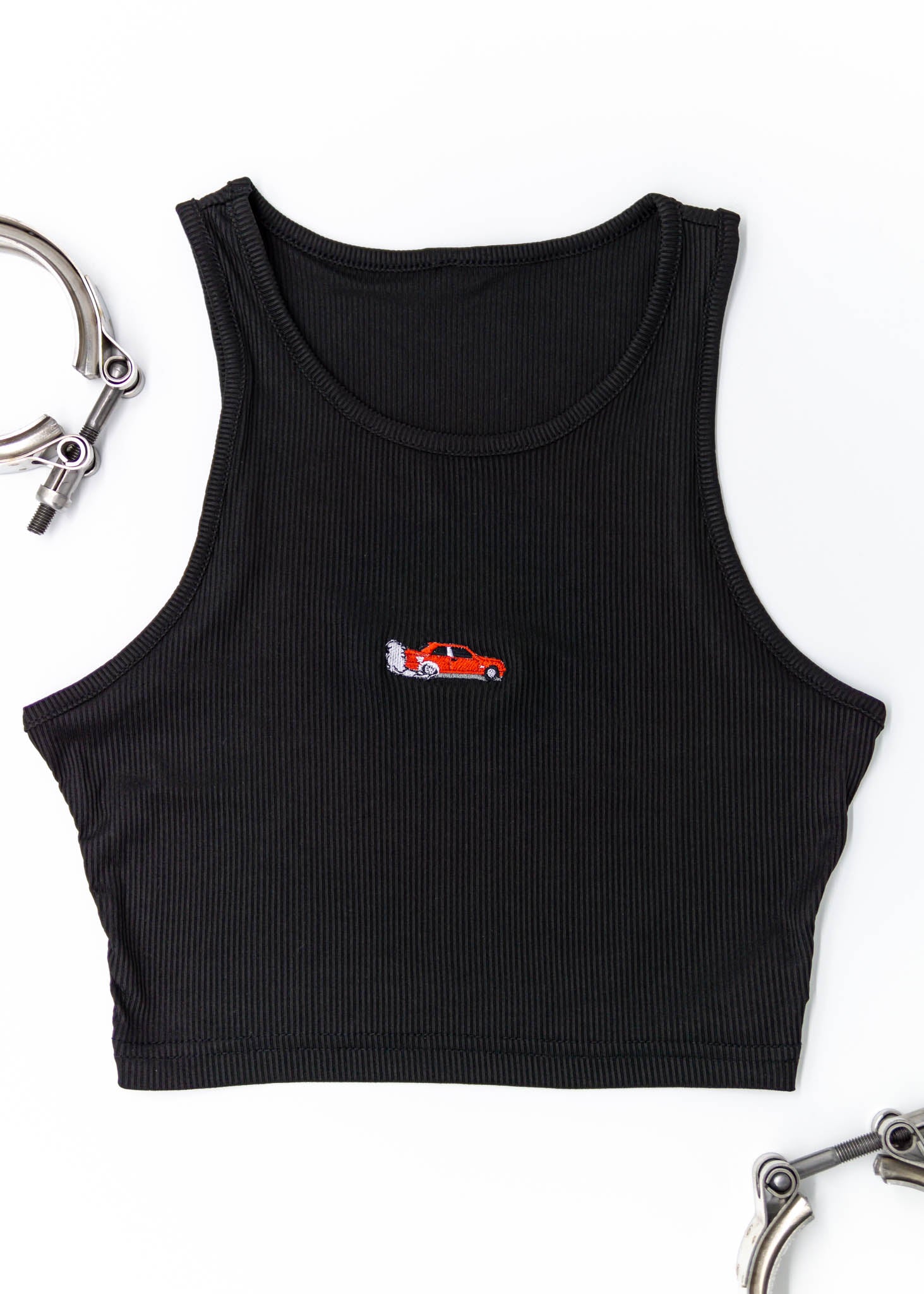 A black BMW Bimmer crop top for women and plus size women. Photo is a front view of the shirt with an embroidered Red E30 M3 doing a burnout. Fabric composition is a polyester, and elastine mix. The material is very stretchy, comfortable, and non-transparent. The style of this shirt is sleeveless, tank top straps, with crewneck neckline.