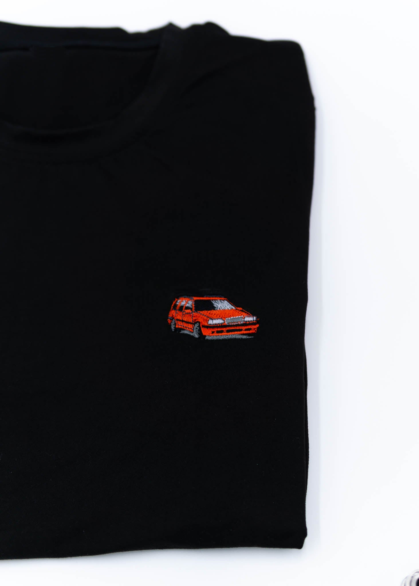 A black Volvo t-shirt for men. Photo is a close up view of the shirt with an embroidered red 850R. Fabric composition is a polyester, and cotton mix. The material is very soft, stretchy, non-transparent. The style of this shirt is short sleeve, with a crewneck neckline.