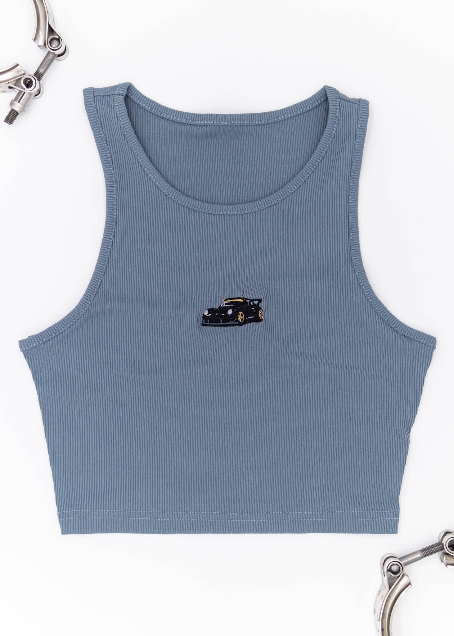 A blue RWB Porsche 930 911 Turbo crop top for women. Photo is a front view of the shirt with Akira Nakai's RWB Porsche 930 911 Turbo Stella Artois. Fabric composition is a polyester, and elastine mix. The material is very stretchy, comfortable, and non-transparent. The style of this shirt is sleeveless, tank top straps, with crewneck neckline.