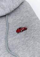 A grey E36 M3 cropped hoodie for women. Photo is a close up view of the cropped sweater with an embroidered E36 M3. Fabric composition is cotton, and polyester. The material is soft, stretchy, and non-transparent. The style of this crop hoodie is long sleeve, crewneck with a hood, hooded, with embroidery on the chest.