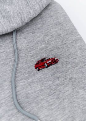 A grey E36 M3 cropped hoodie for women. Photo is a close up view of the cropped sweater with an embroidered E36 M3. Fabric composition is cotton, and polyester. The material is soft, stretchy, and non-transparent. The style of this crop hoodie is long sleeve, crewneck with a hood, hooded, with embroidery on the chest.