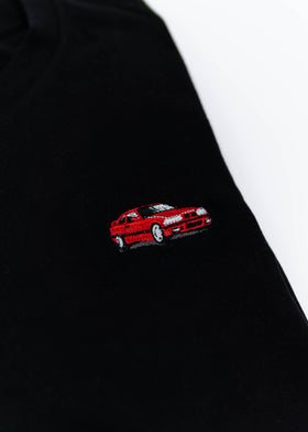 A black E36 M3 T-Shirt for men. Photo is a close up view of the shirt with an embroidered red E36 M3. Fabric composition is 65% polyester, and 35% cotton. The material is very stretchy, soft, comfortable, breathable, and non-transparent. The style of this shirt is short sleeve, with a crewneck neckline.