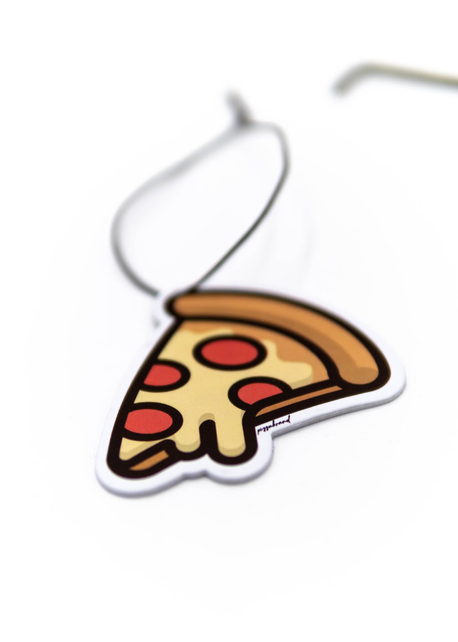 A pizzabrand pepperoni pizza air freshener. Photo is a close up of the car air freshener with string.