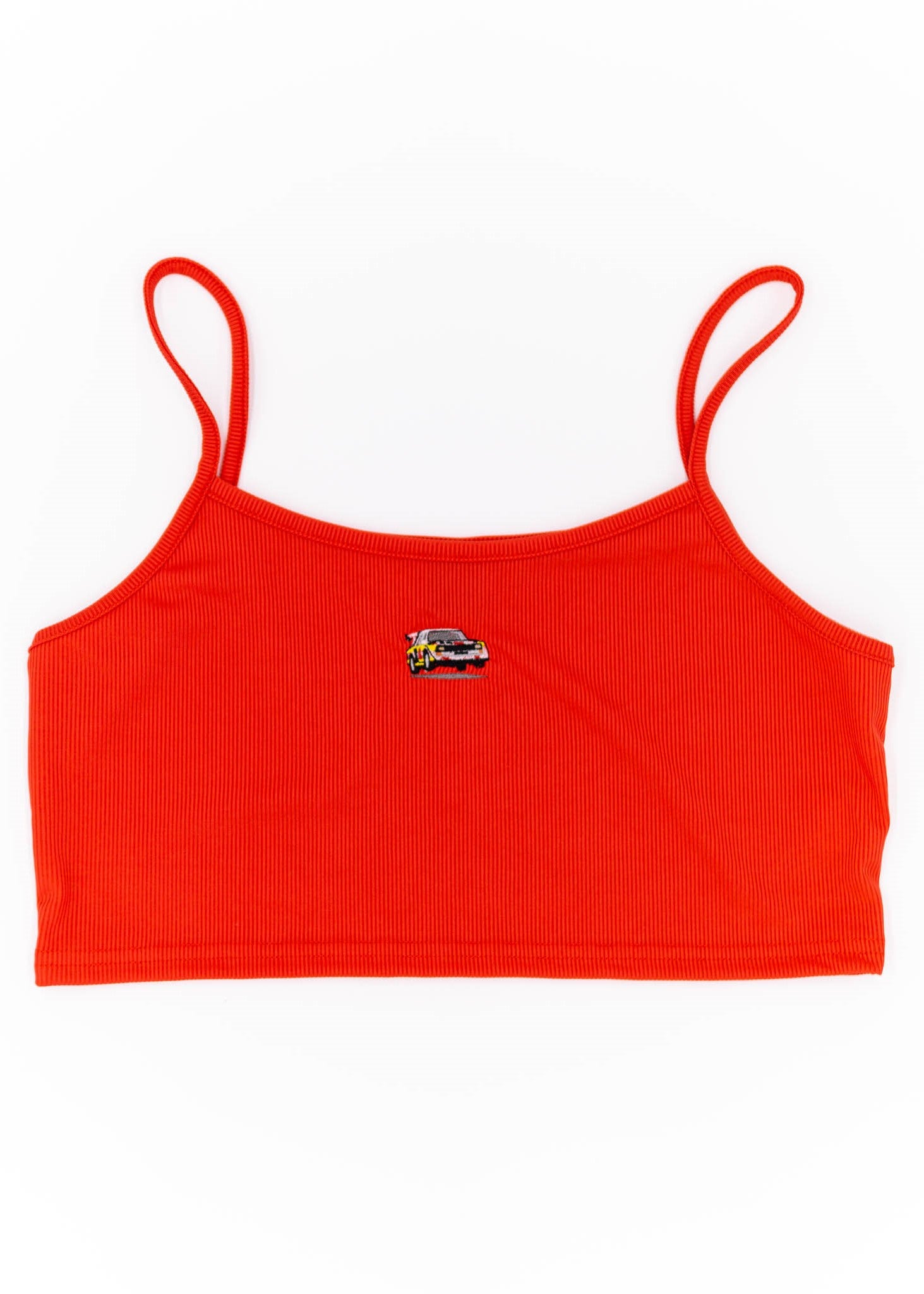 A red Audi crop top for plus size women. Photo is a front view of the top with an embroidered Sport Quattro S1 E2. Fabric composition is 100% polyester. The material is stretchy, ribbed, and non-transparent. The style of this shirt is sleeveless, with a scoop neckline.