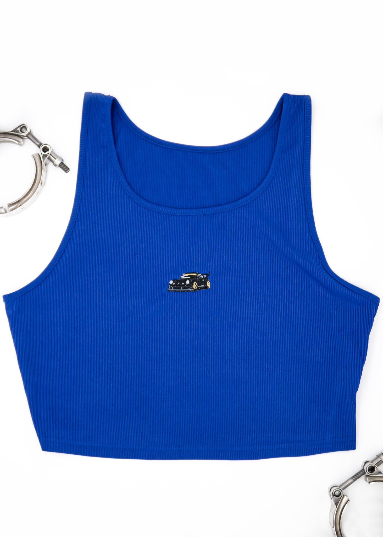 A blue RWB Porsche 930 911 Turbo crop top for plus size women. Photo is a front view of the shirt with Akira Nakai's RWB Porsche 930 911 Turbo Stella Artois. Fabric composition is a polyester, and elastine mix. The material is very stretchy, comfortable, and non-transparent. The style of this shirt is sleeveless, tank top straps, with crewneck neckline.