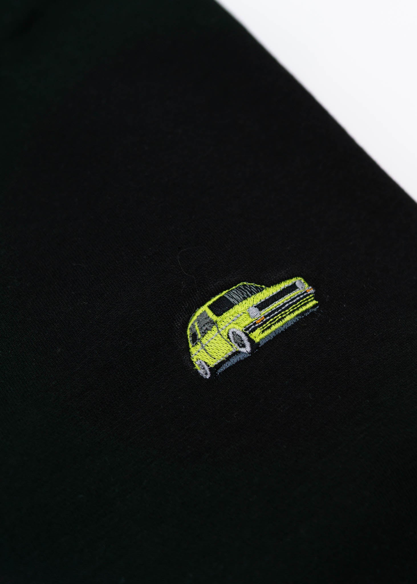 A black VW Volkswagen crewneck sweater for men. Photo is a close up of the sweater with an embroidered modified green VW Mk1 Golf. Fabric is 100% cotton and high quality and fits to size. The style is long sleeve, crew neck, and embroidery on left chest.