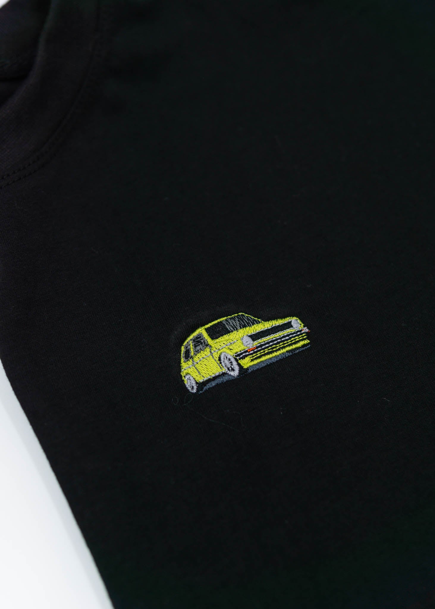 A black cropped t-shirt for VW women and plus size women. Close up of a 100% cotton crop tee with an embroidered VW Mk1 Golf. The material is stretchy, and non-transparent with a crewneck neckline and short sleeves.