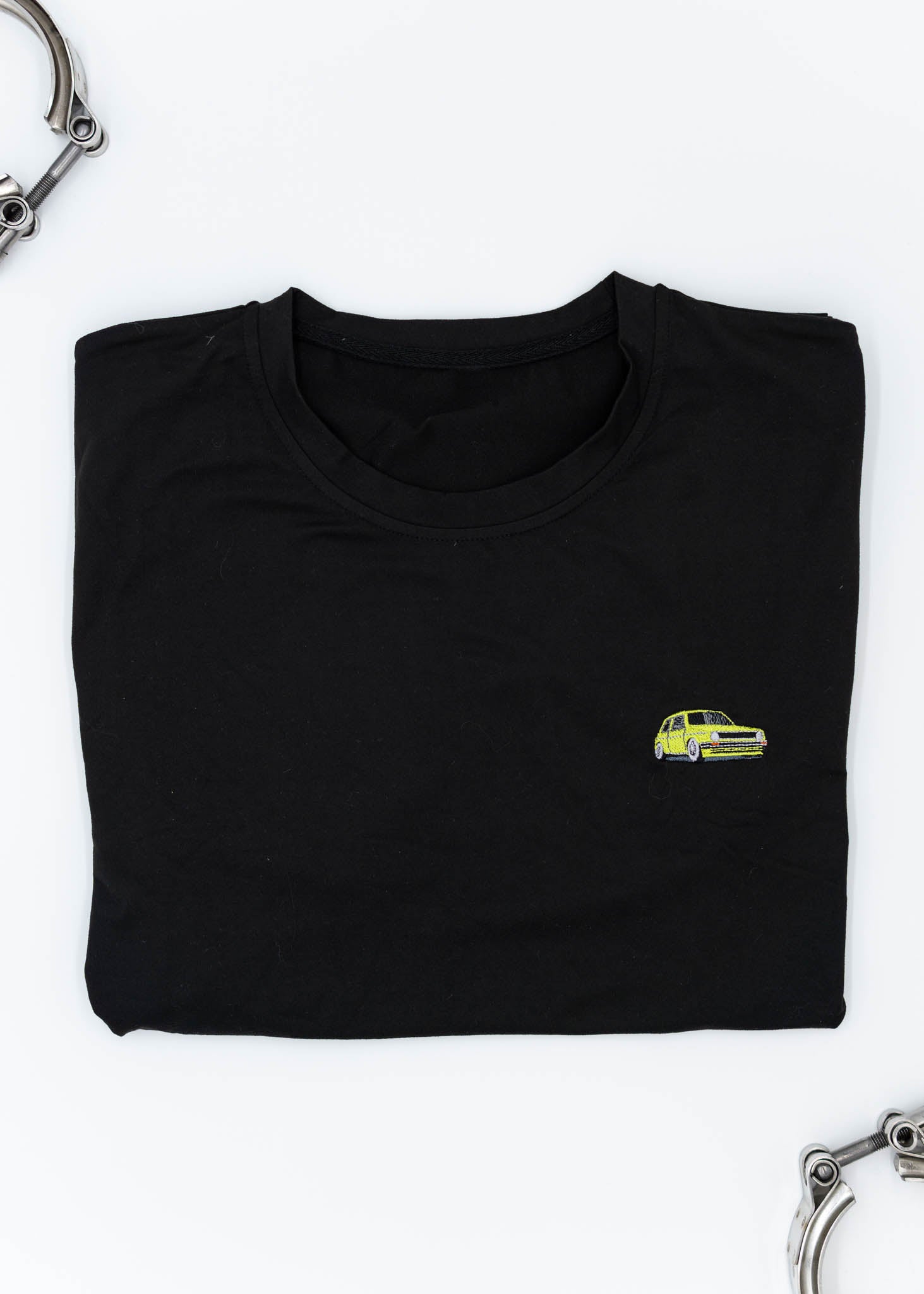 A black VW VolkswagenT-Shirt for men. Photo is a front view of the shirt with an embroidered modified green Mk1 Golf. Fabric composition is 100% polyester. The material is very stretchy, soft, comfortable, breathable, and non-transparent. The style of this shirt is short sleeve, with a crewneck neckline.